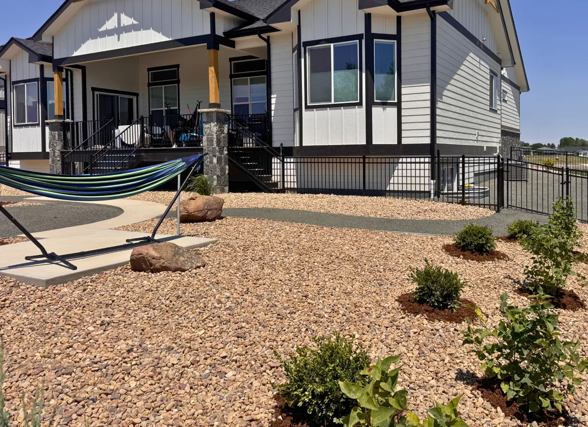 Overgrown lot to rock and plantings, after